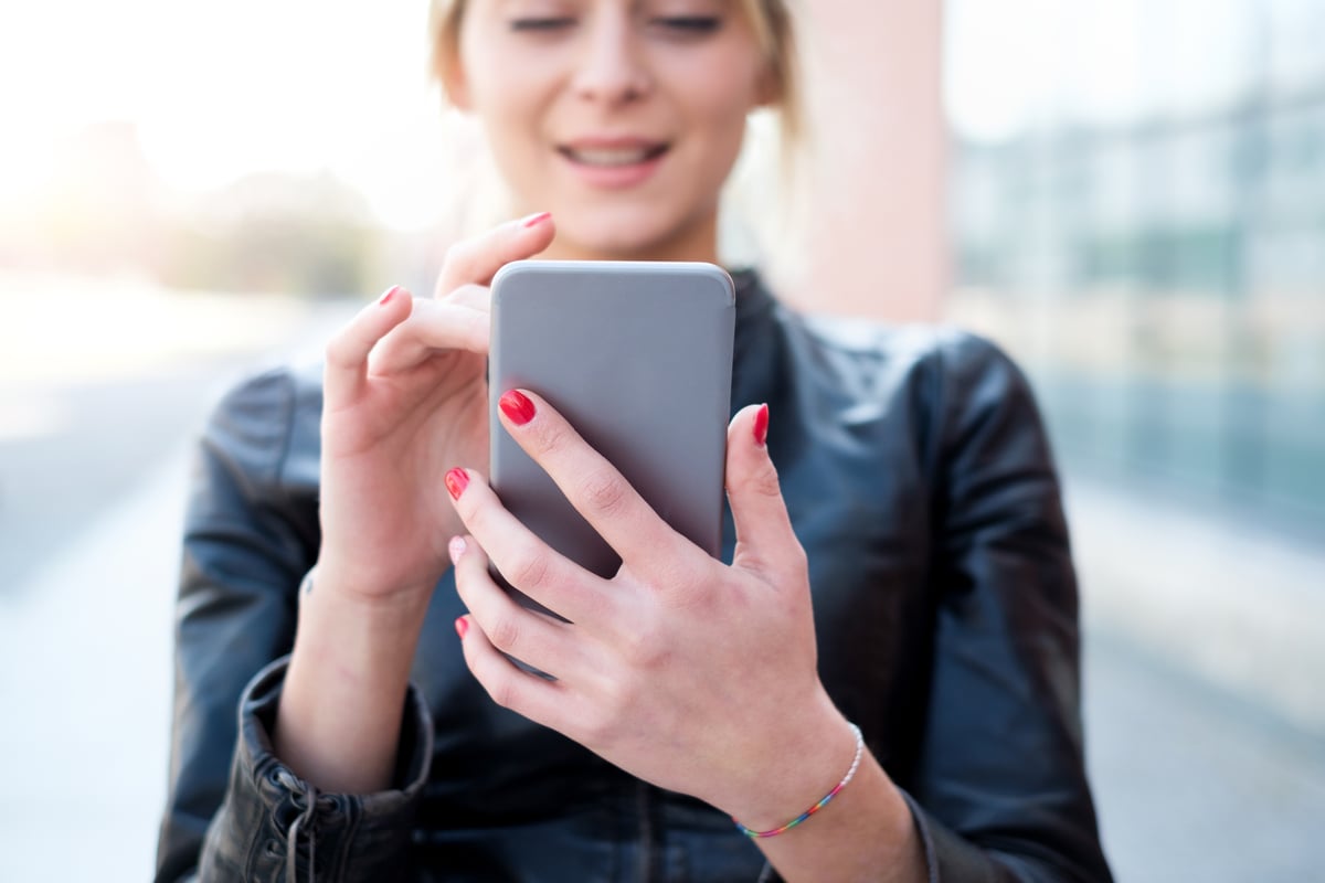 A person is smiling while using a dating app on a mobile phone.